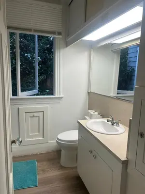 a bathroom with a toilet and a sink and a mirror at Budget Vancouver Rooms Near YVR - Free Parking, Fast WiFi in Vancouver