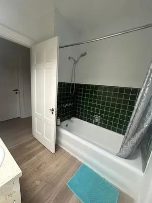 a bathroom with a tub and a green tiled wall at Vancouver Airport & UBC Private Rooms - Free Parking, Fast Wifi in Vancouver