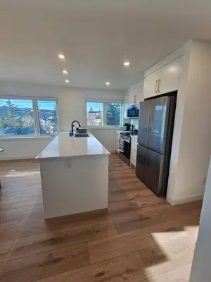 a kitchen with a white counter and a refrigerator at Comfortable Home Near Hospitals and Parks in Calgary
