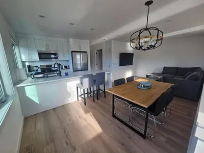 a living room and kitchen with a table and chairs at Comfortable Home Near Hospitals and Parks in Calgary