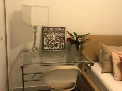a glass table with a chair next to a bed at Quiet-comfy 3 bedroom house on a tree lined street in Kitsilano in Vancouver