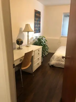 a bedroom with a desk with a lamp and a bed at Quiet-comfy 3 bedroom house on a tree lined street in Kitsilano in Vancouver