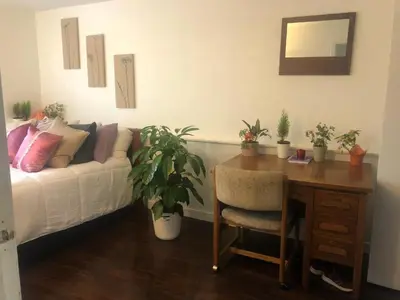 a living room with a couch and a desk with a table and a tableablish at Quiet-comfy 3 bedroom house on a tree lined street in Kitsilano in Vancouver