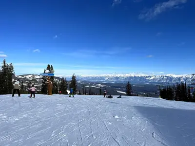 a group of people skiing down a snow covered slope at Polaris Lodge by StayIn in Kimberley