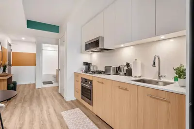 a kitchen with wooden cabinets and a sink in a room at Spacious and elegant| 2 Kng Beds| Space for all in Calgary
