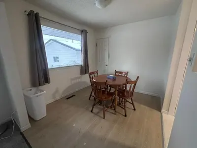 a dining room with a table and chairs and a window at Cozy West Edmonton Home Near Jasper Park & shops in Edmonton