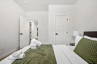 a bedroom with a bed with towels on it at Spacious Modern 3 Bedroom Basement Suite in Calgary
