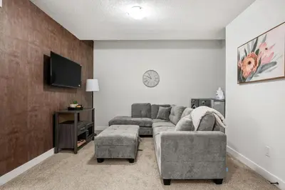 a living room with two couches and a tv at Spacious Modern 3 Bedroom Basement Suite in Calgary