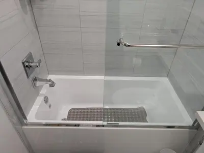a bath tub with a bench in a bathroom at Modern 2BR Suite Steps to SkyTrain in Vancouver