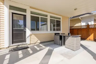 a house with a patio with a table and chairs at Beautiful abode in Abbotsford in Abbotsford