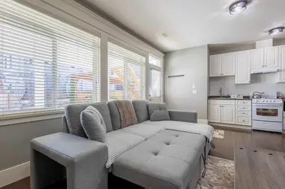 a living room with a couch and a kitchen at Beautiful abode in Abbotsford in Abbotsford