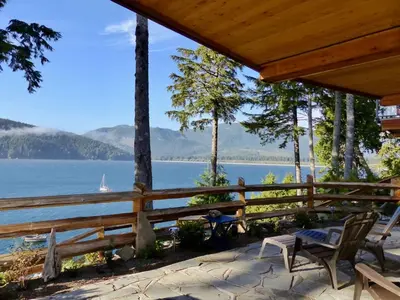 a porch with chairs and a view of a lake at Wickham's Wake - 3BR Oceanfront - pet friendly in Port Renfrew