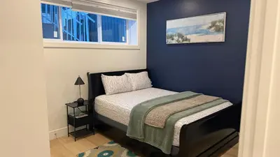 a small bedroom with a bed and a window at Modern 1BR Private Suite NW Near Airport & Amazing Shopping! Free Netflix, Parking! in Calgary