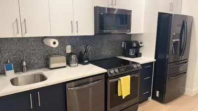 a kitchen with a sink and a stove and a refrigerator at Modern 1BR Private Suite NW Near Airport & Amazing Shopping! Free Netflix, Parking! in Calgary