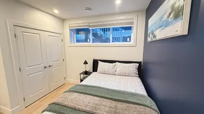 a small bedroom with a bed and a window at Modern 1BR Private Suite NW Near Airport & Amazing Shopping! Free Netflix, Parking! in Calgary