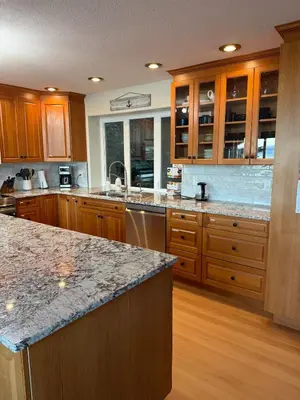 a large kitchen with wooden cabinets and granite counter tops at Woodhaven - Entire Home, Ocean Front in Bowser