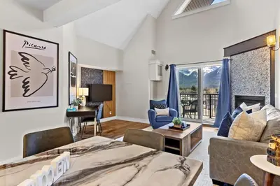 a living room with a bed and a couch at Stunning Penthouse with Mtn Views Hot Tub and Pool in Canmore
