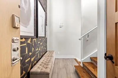 a hallway with a stairway with a couch next to a door at Stunning Penthouse with Mtn Views Hot Tub and Pool in Canmore