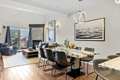 a dining room and living room with a table and chairs at Stunning Penthouse with Mtn Views Hot Tub and Pool in Canmore