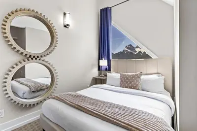 a bedroom with a bed and a mirror at Stunning Penthouse with Mtn Views Hot Tub and Pool in Canmore