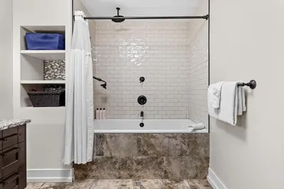 a white bathroom with a tub and a shower at Stunning Penthouse with Mtn Views Hot Tub and Pool in Canmore