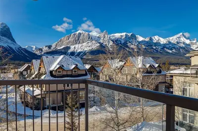 a view of a town with snow covered mountains at Stylish Mountain View Condo with Gym in Canmore