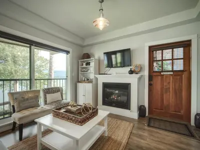 a living room with a couch and a fireplace at Oceanfront Suite with Hot Tub - No Pets - Sleep 4 in Port Renfrew