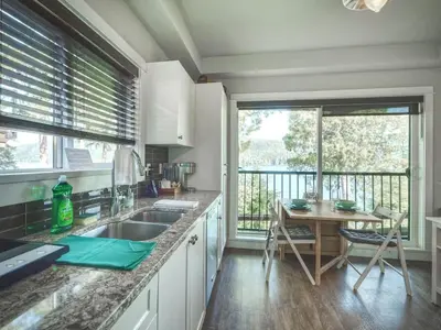 a kitchen with a sink and a table with a view at Oceanfront Suite with Hot Tub - No Pets - Sleep 4 in Port Renfrew