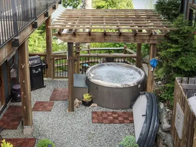 an outdoor hot tub under a wooden pergola at Oceanfront Suite with Hot Tub - No Pets - Sleep 4 in Port Renfrew