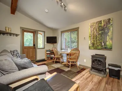 a living room with a couch and a stove at Explorer's Retreat Sauna & Bunkhouse & Fire pit in Port Renfrew