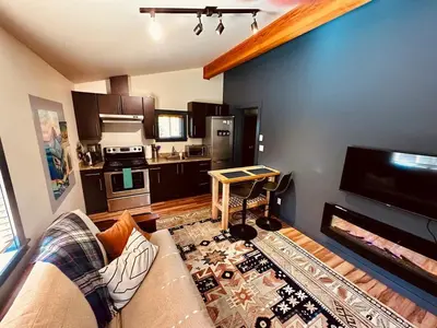a living room with a couch and a kitchen at Hot Tub - Large Fully Enclosed deck - Pet Friendly in Port Renfrew