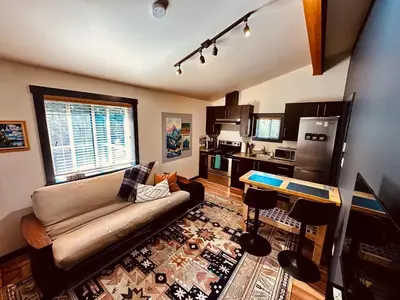 a living room with a couch and a kitchen at Hot Tub - Large Fully Enclosed deck - Pet Friendly in Port Renfrew