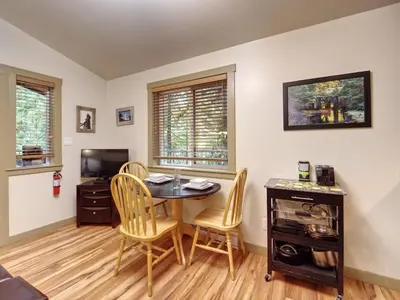 a dining room with a table and chairs and a television at Hot tub Oasis Among Trees - Pet Friendly in Port Renfrew