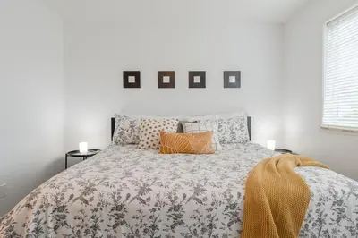 a white bedroom with a large bed with pillows at Cozy Large Family Home near Lake, AC, Full Kitchen in Calgary