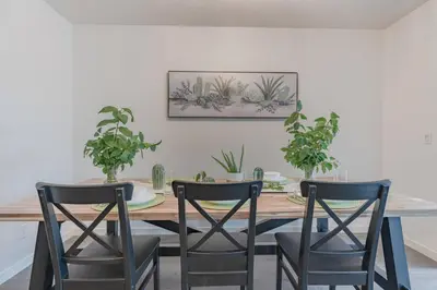 a dining room table with two chairs and potted plants at Cozy Large Family Home near Lake, AC, Full Kitchen in Calgary