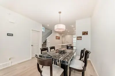 a dining room with a black table and chairs at Cozy 3 beds 2 and half baths 2 Story Home in Calgary