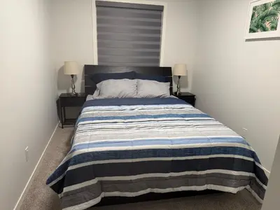 a bedroom with a bed with a striped blanket at Cozy 3 beds 2 and half baths 2 Story Home in Calgary