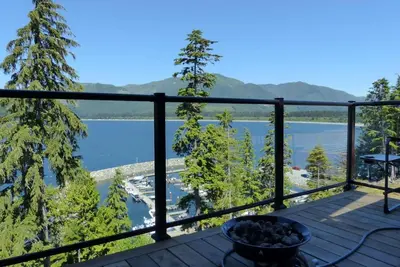 a balcony with a view of a lake at Amazing Marina & Oceanfront View - Pet Friendly - Sleeps 6 in Port Renfrew