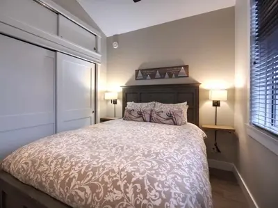 a bedroom with a large bed with two lamps on it at Amazing Marina & Oceanfront View - Pet Friendly - Sleeps 6 in Port Renfrew