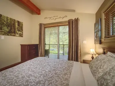 a bedroom with a large bed and a window at Hot Tub - Pet Friendly - Cozy Escape with Fire Pit in Port Renfrew