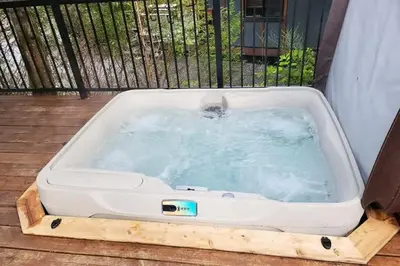 a dog in a hot tub on a deck at Hot Tub - Pet Friendly - Cozy Escape with Fire Pit in Port Renfrew