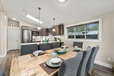 a kitchen and dining room with a wooden table and chairs at Seaside Haven -Hot Tub with Oceanfront View in Port Renfrew