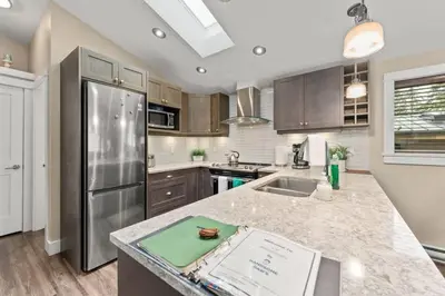 a kitchen with stainless steel appliances and wooden cabinets at Seaside Haven -Hot Tub with Oceanfront View in Port Renfrew