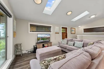 a living room with a couch and a tv at Seaside Haven -Hot Tub with Oceanfront View in Port Renfrew