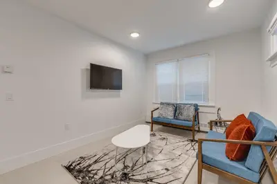 a living room with two chairs and a tv at Spacious Apartment Fully Equipped in Prime Location in Vancouver