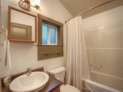 a bathroom with a sink and a toilet and a shower at Enclosed deck - Hot tub - Pet Friendly- gas stove in Port Renfrew