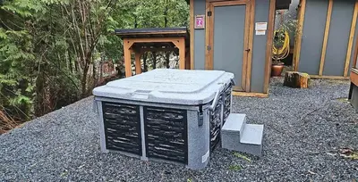 a appliance sitting on the ground in front of a house at Enclosed deck - Hot tub - Pet Friendly- gas stove in Port Renfrew