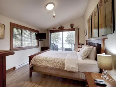a bedroom with a large bed and a window at Tiltin Hilton- Ocean View - Pet Friendly - sleep 4 in Port Renfrew