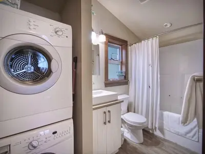 a bathroom with a washing machine and a toilet at Tiltin Hilton- Ocean View - Pet Friendly - sleep 4 in Port Renfrew