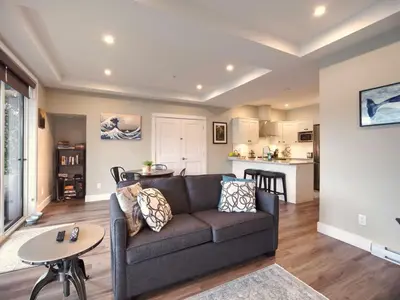 a living room with a couch and a table at Oceanfront Relaxing & Stunning View - Pet Friendly in Port Renfrew
